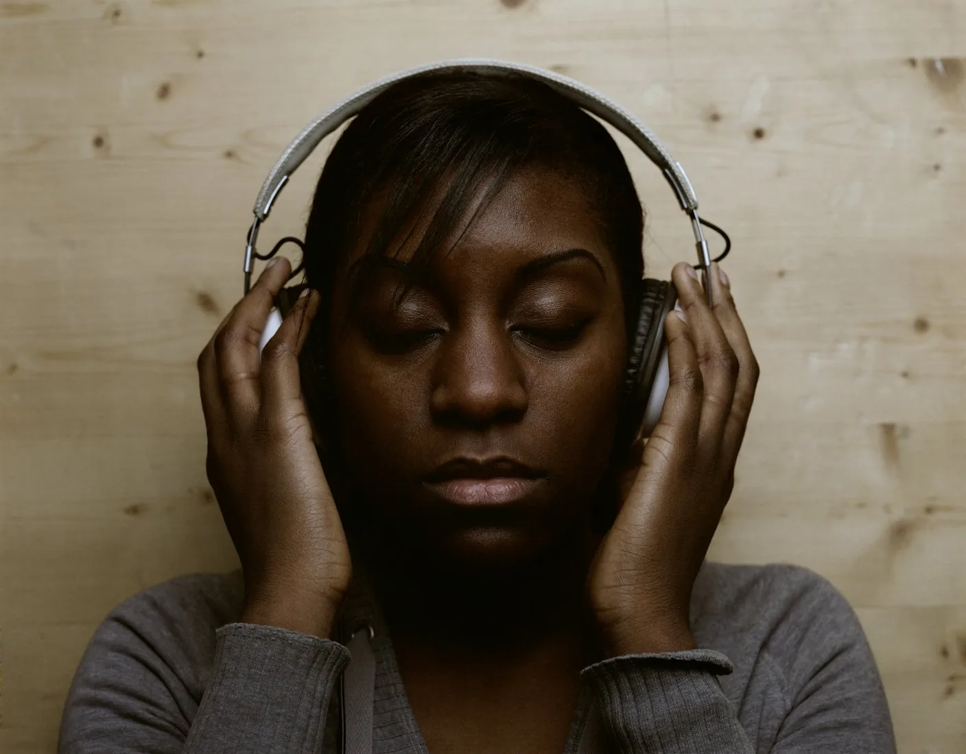 A woman with eyes closed, listening on headphones